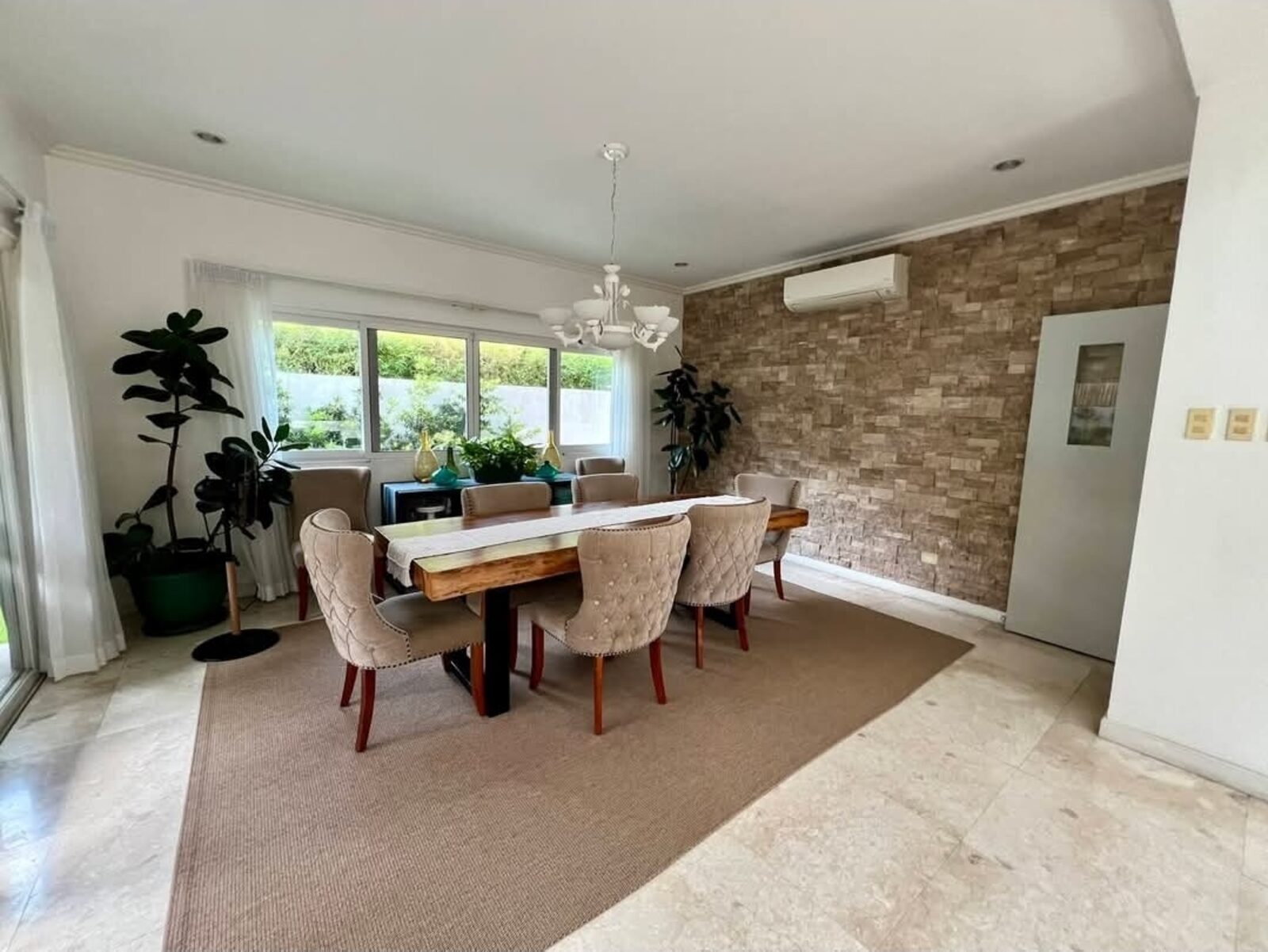 Formal dining room with feature stone accent wall and garden-view windows