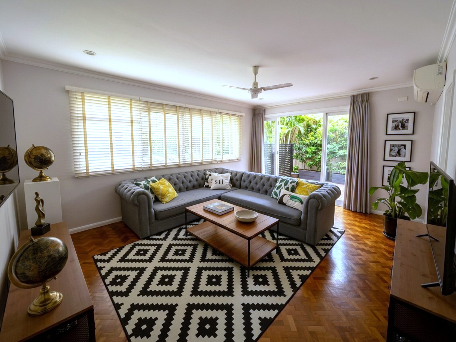 Second living lounge with tufted chesterfield sofa and parquet flooring