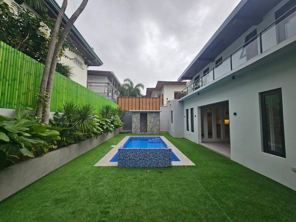 Lush manicured garden corridor framing the pool
