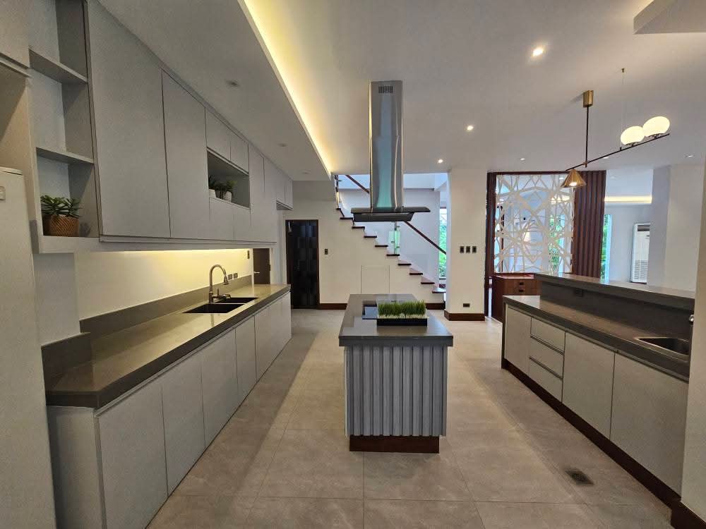 Modern island kitchen with floating staircase backdrop