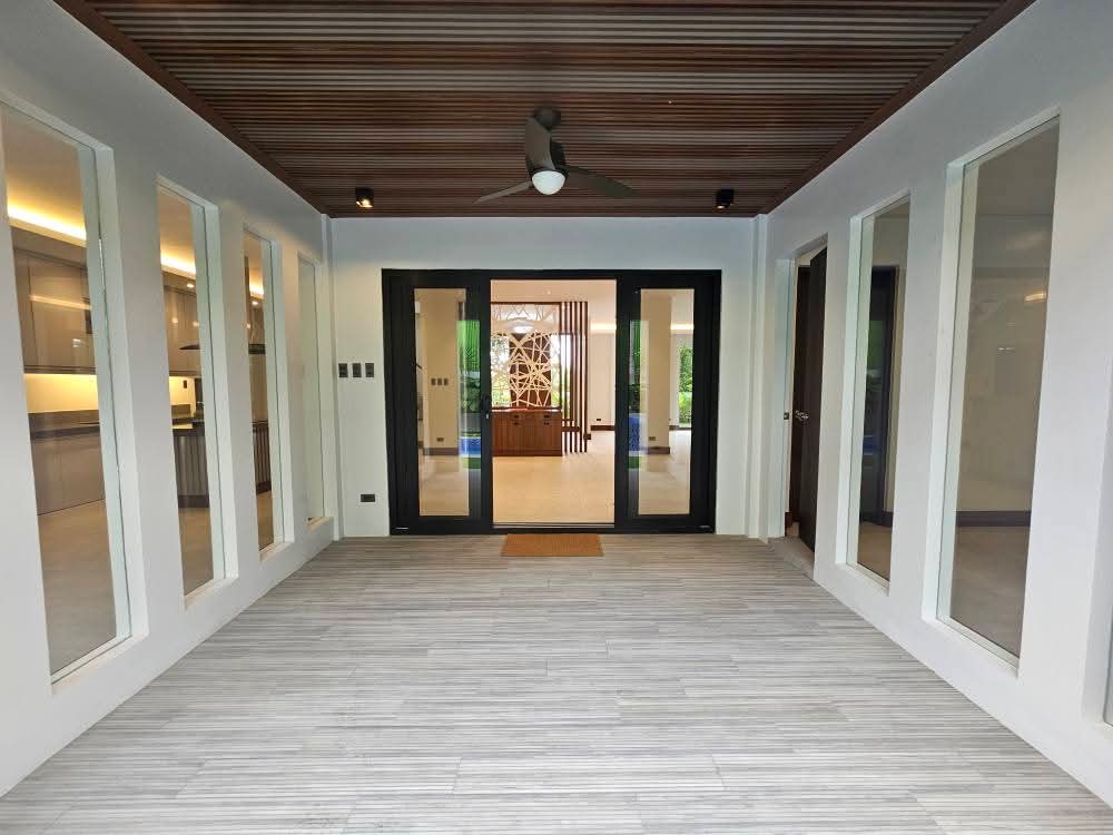 Covered lanai with timber-slat ceiling opening into the main hall
