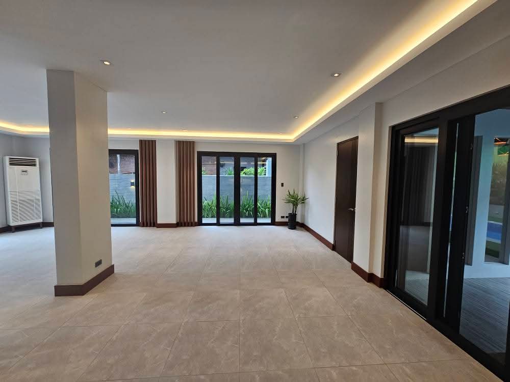 Open-plan living and family room with cove lighting and lanai access