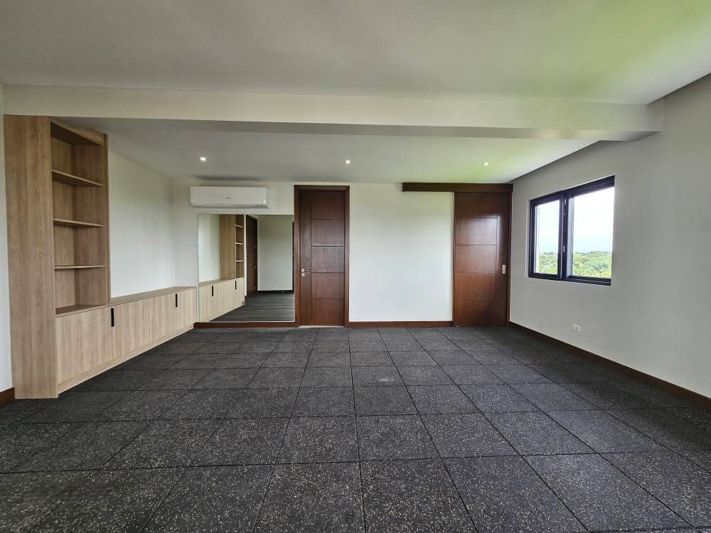 Spacious bedroom with built-in shelving and skyline views