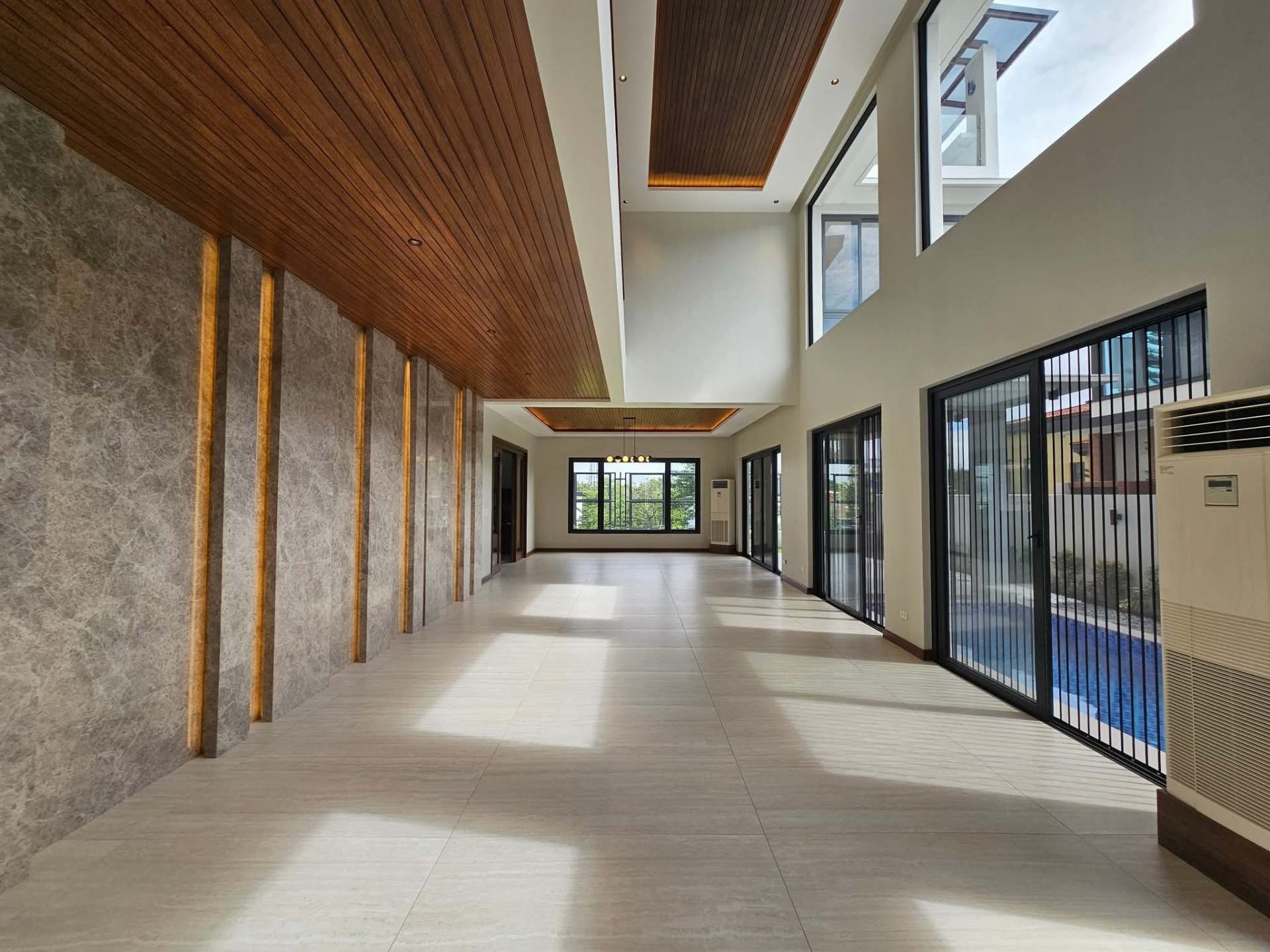 Soaring double-height hallway with timber slat ceiling