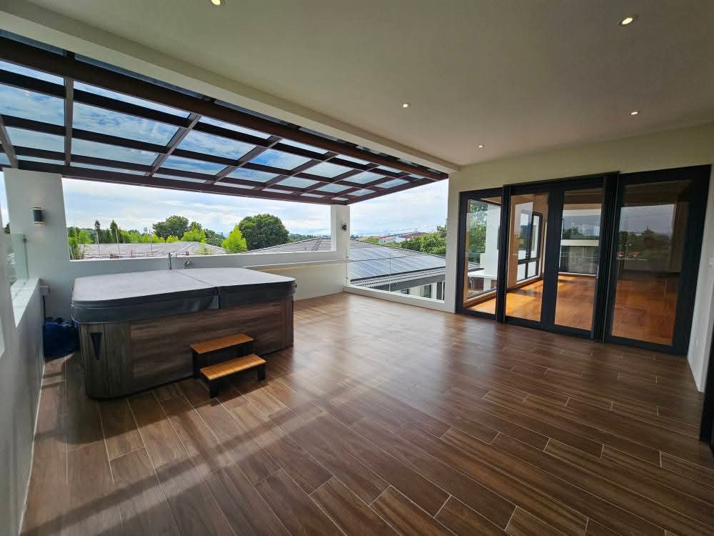 Roof deck with outdoor jacuzzi under a glass pergola