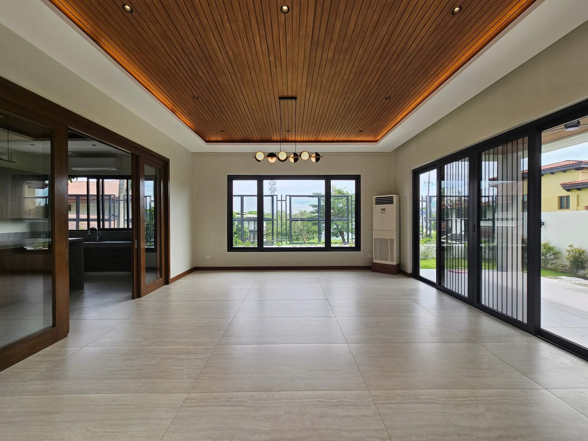 Open living area with coffered timber ceiling and pool views