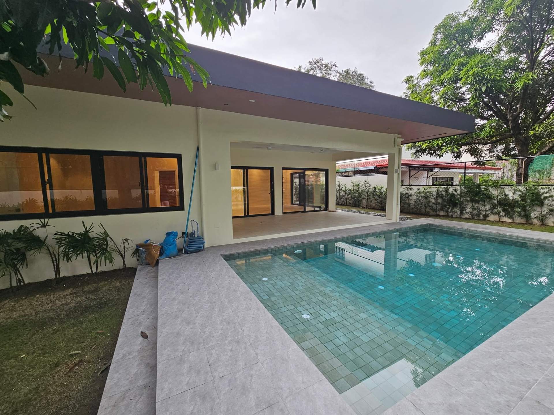 Modern flat-roof facade with full-height glazing onto the pool