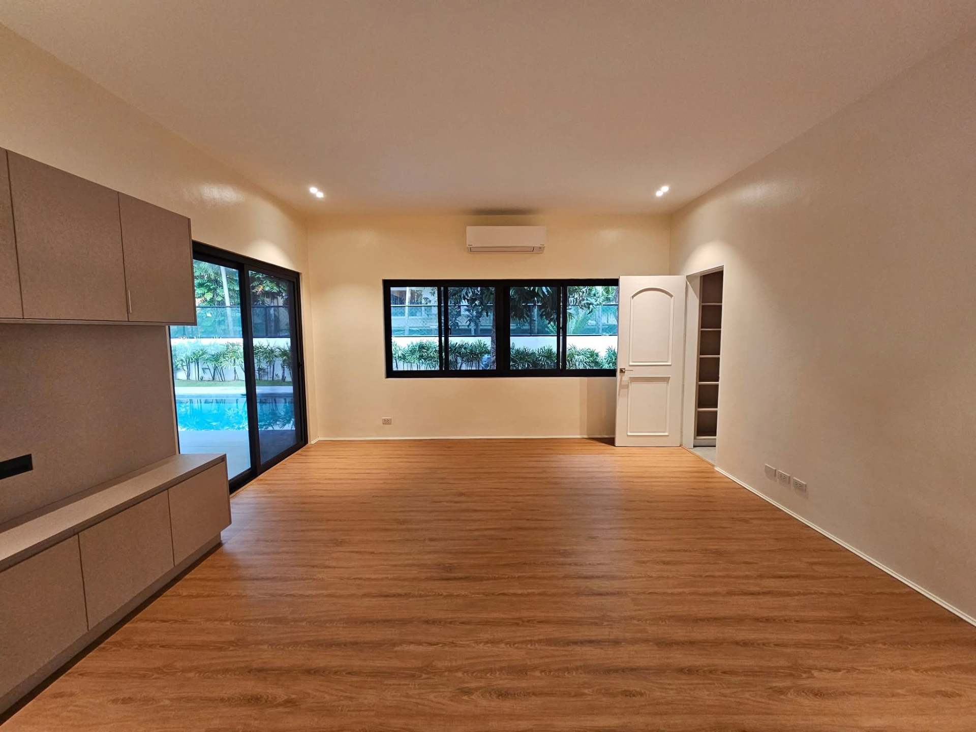 Family room with oak flooring and pool views
