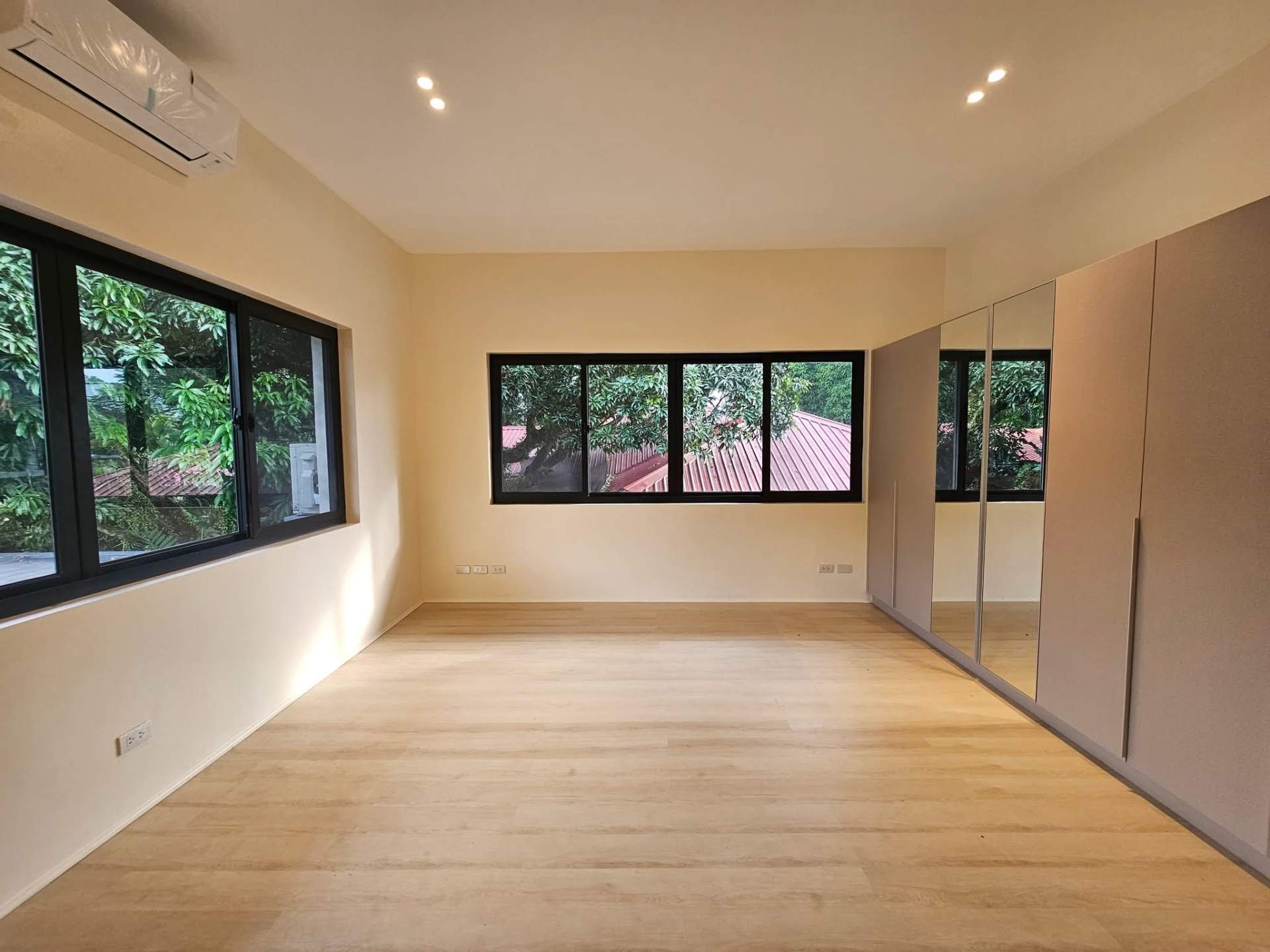 Master suite with mirrored wardrobes and treetop windows