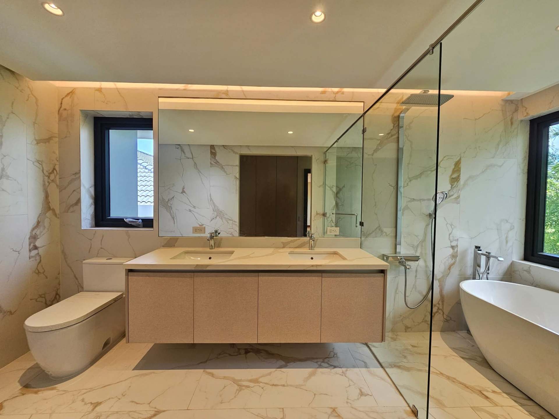 Master bath in book-matched marble with freestanding tub