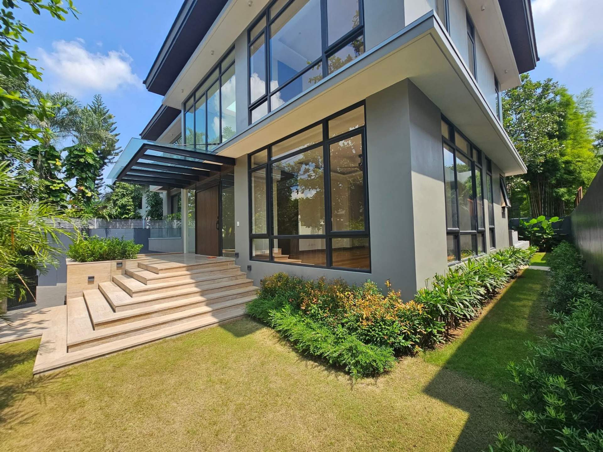 Front entrance with timber door, glass canopy and travertine steps