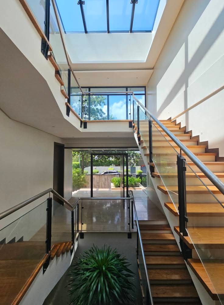 Floating timber staircase under a full-length skylight