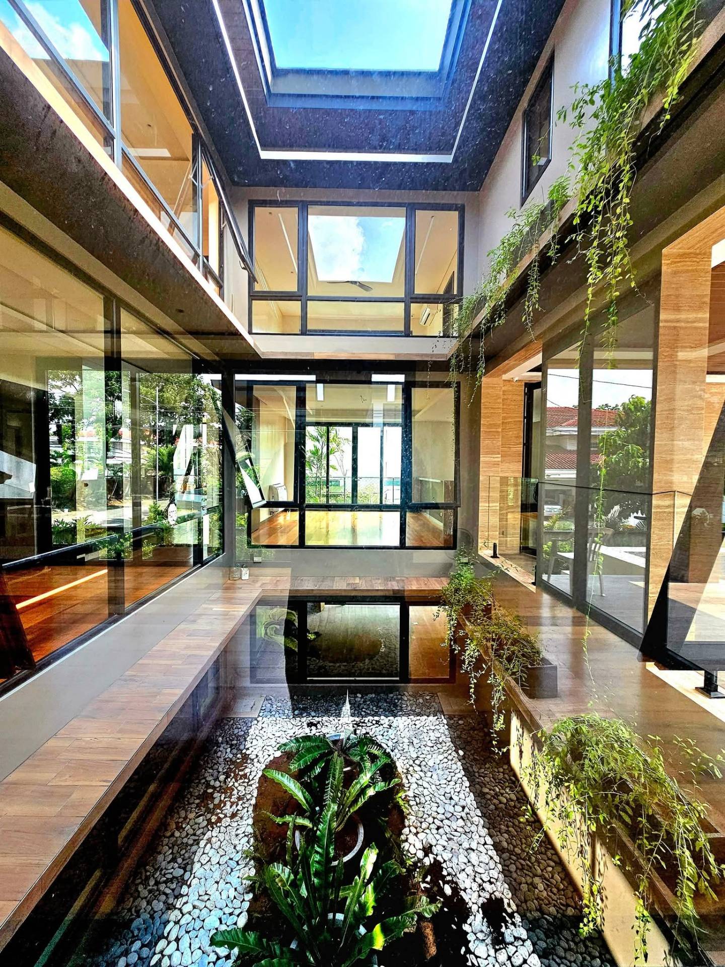 Double-height atrium with skylight, koi pond and hanging vines