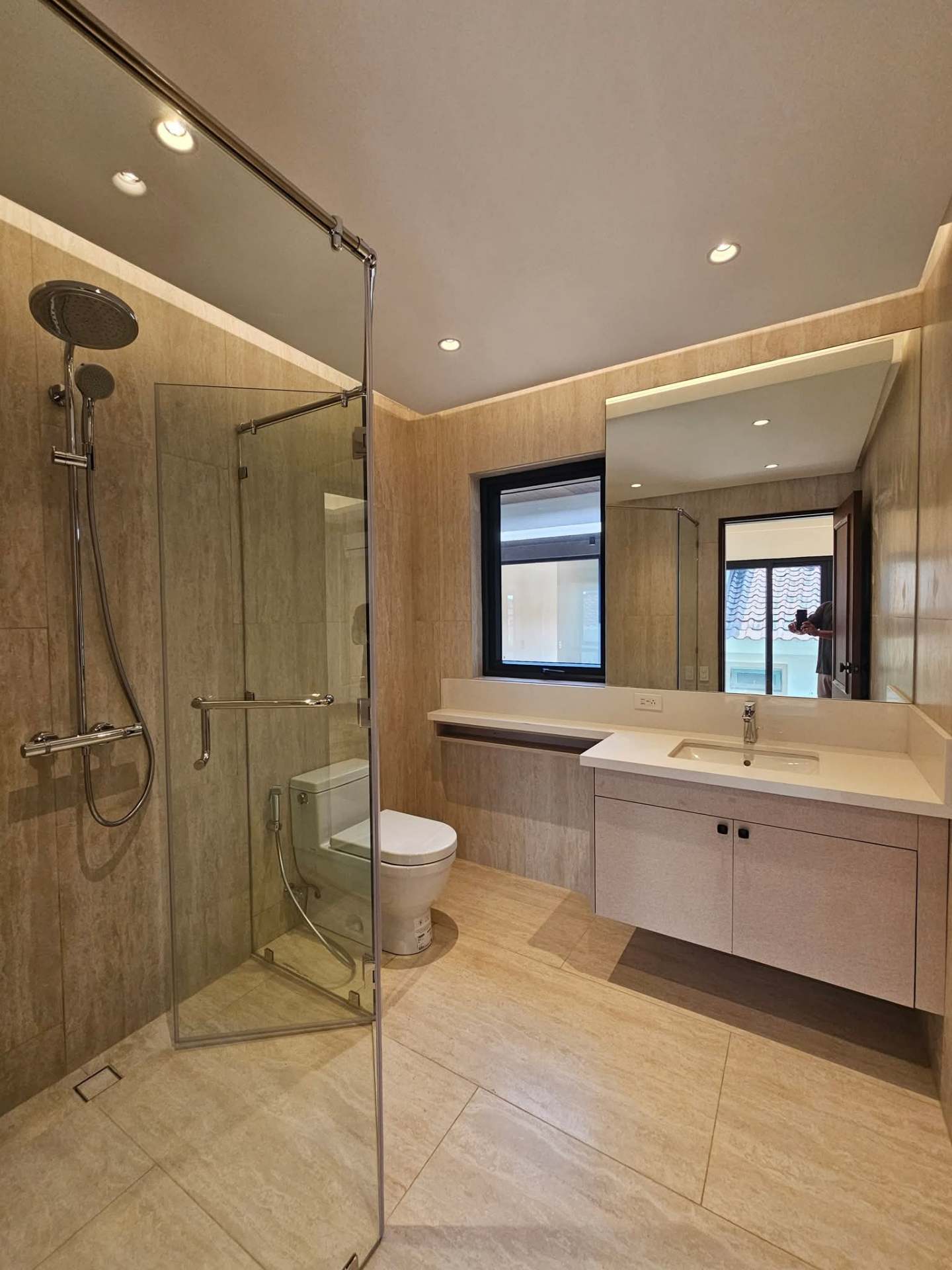 Travertine-clad bedroom bath with rain shower