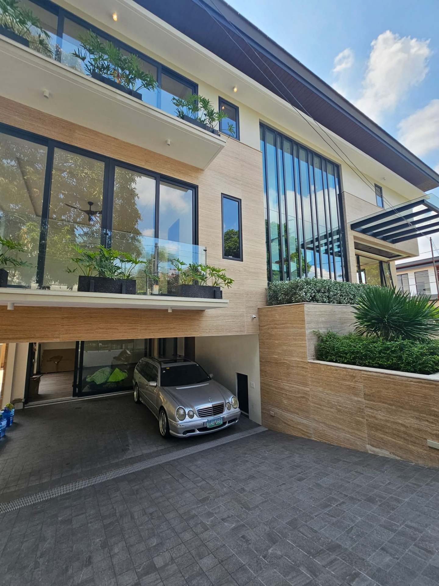 Side driveway and covered carport with travertine walls