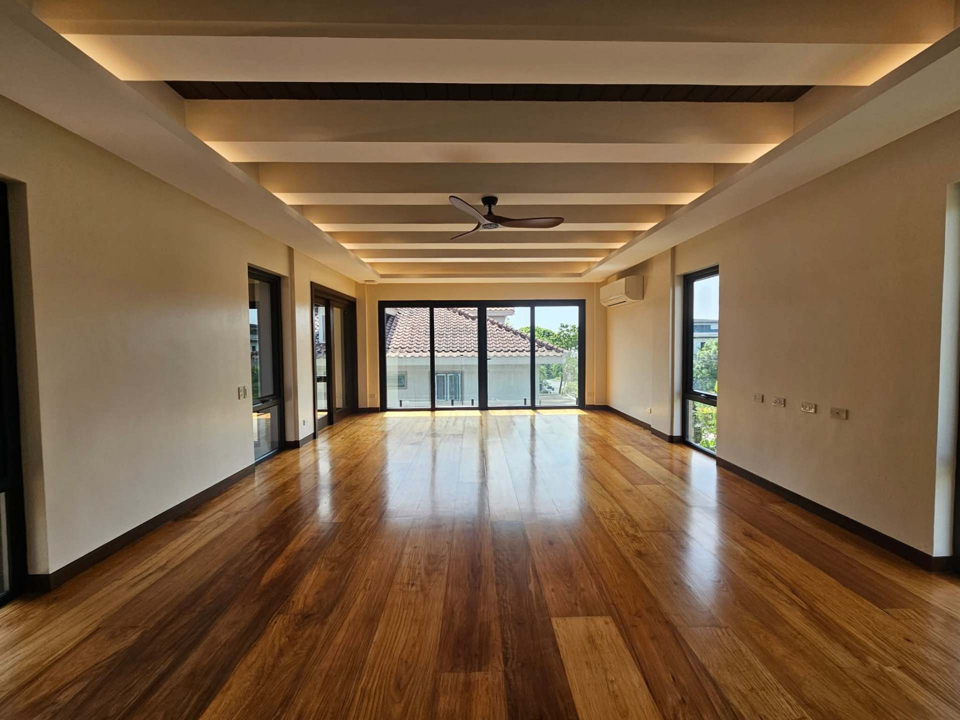 Upper family room with timber-beamed ceiling and Narra floors