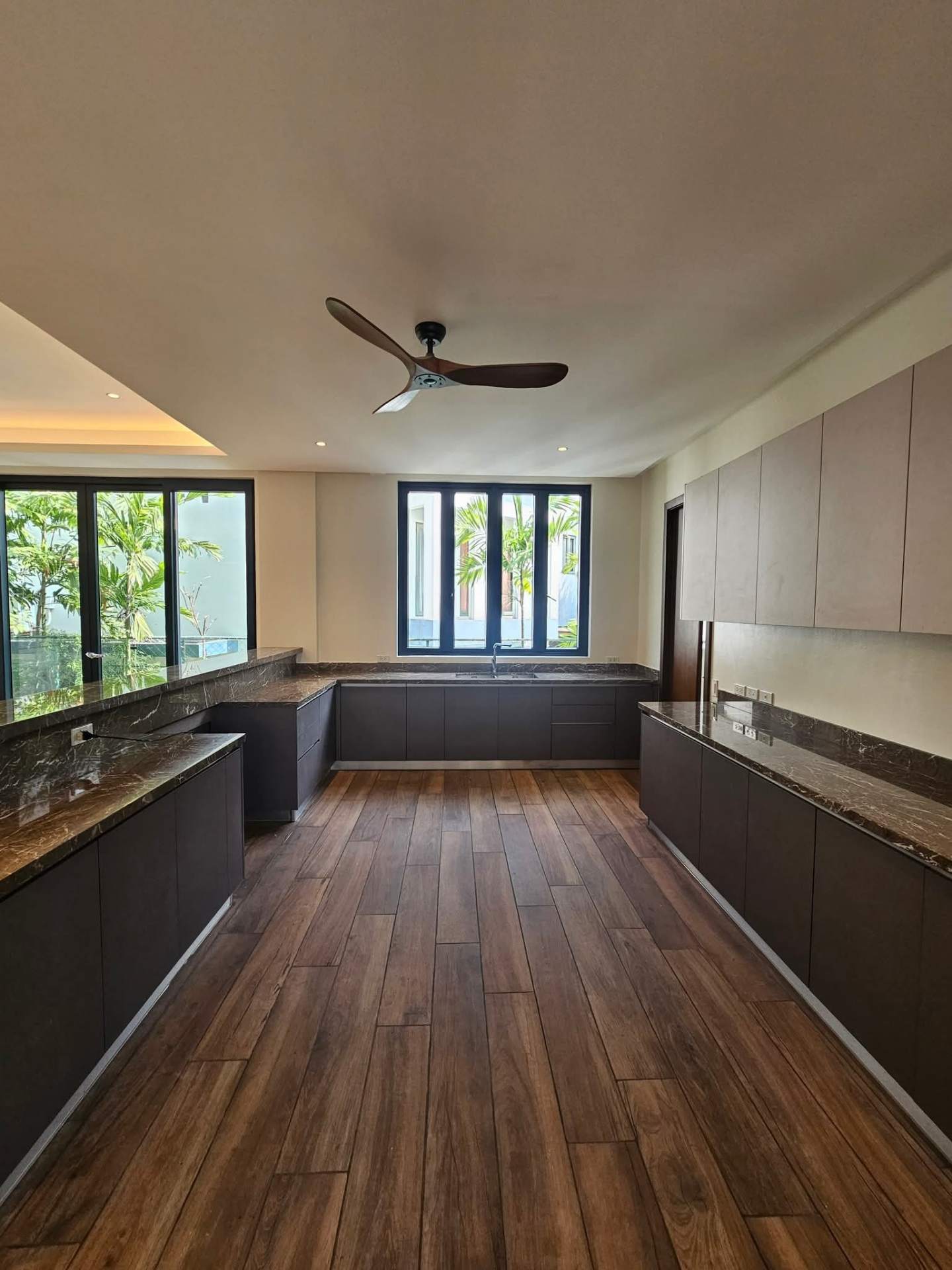 Clean kitchen with stone counters and ceiling fan