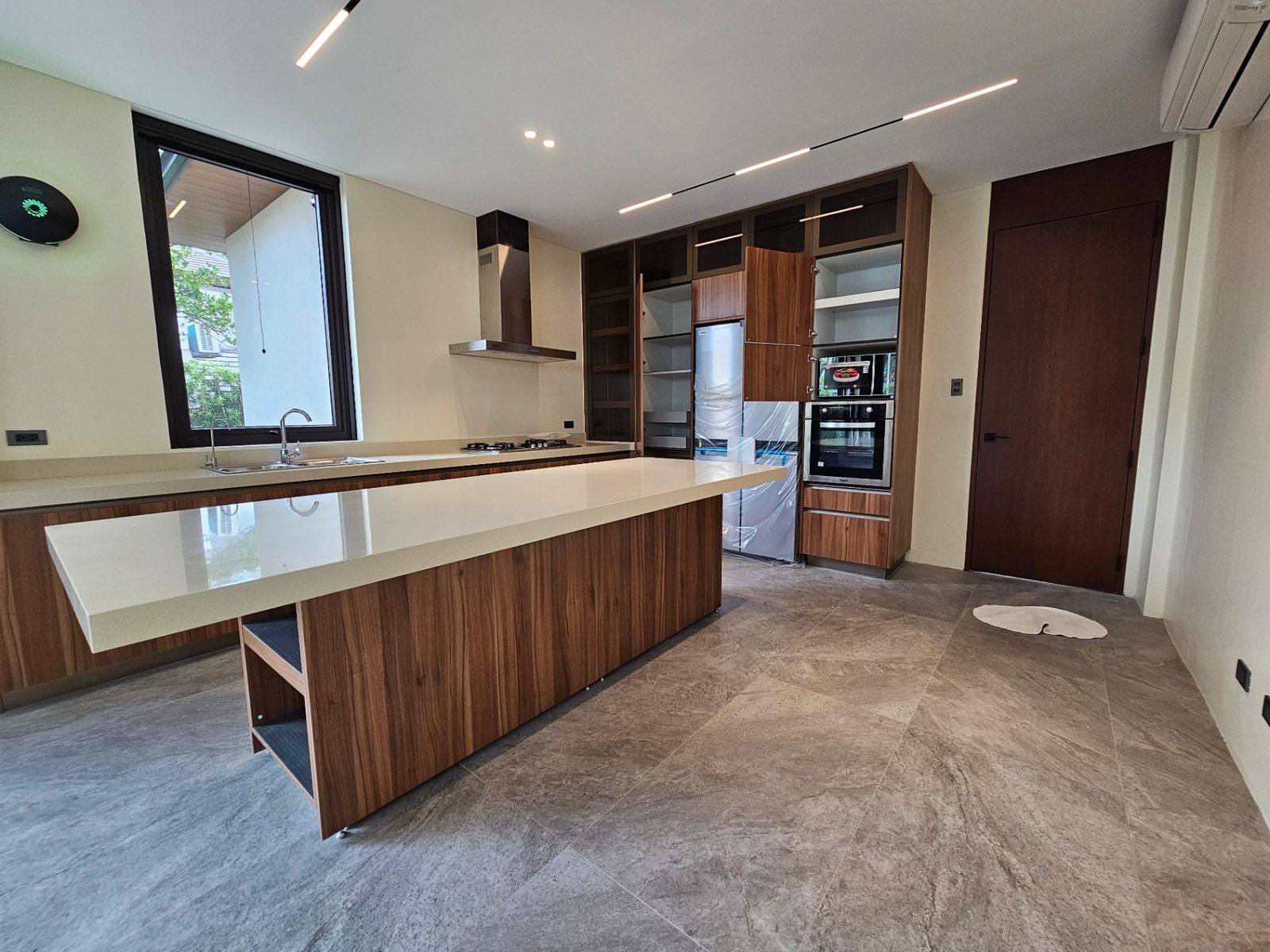 Modern kitchen with large island, walnut cabinetry and stone countertops