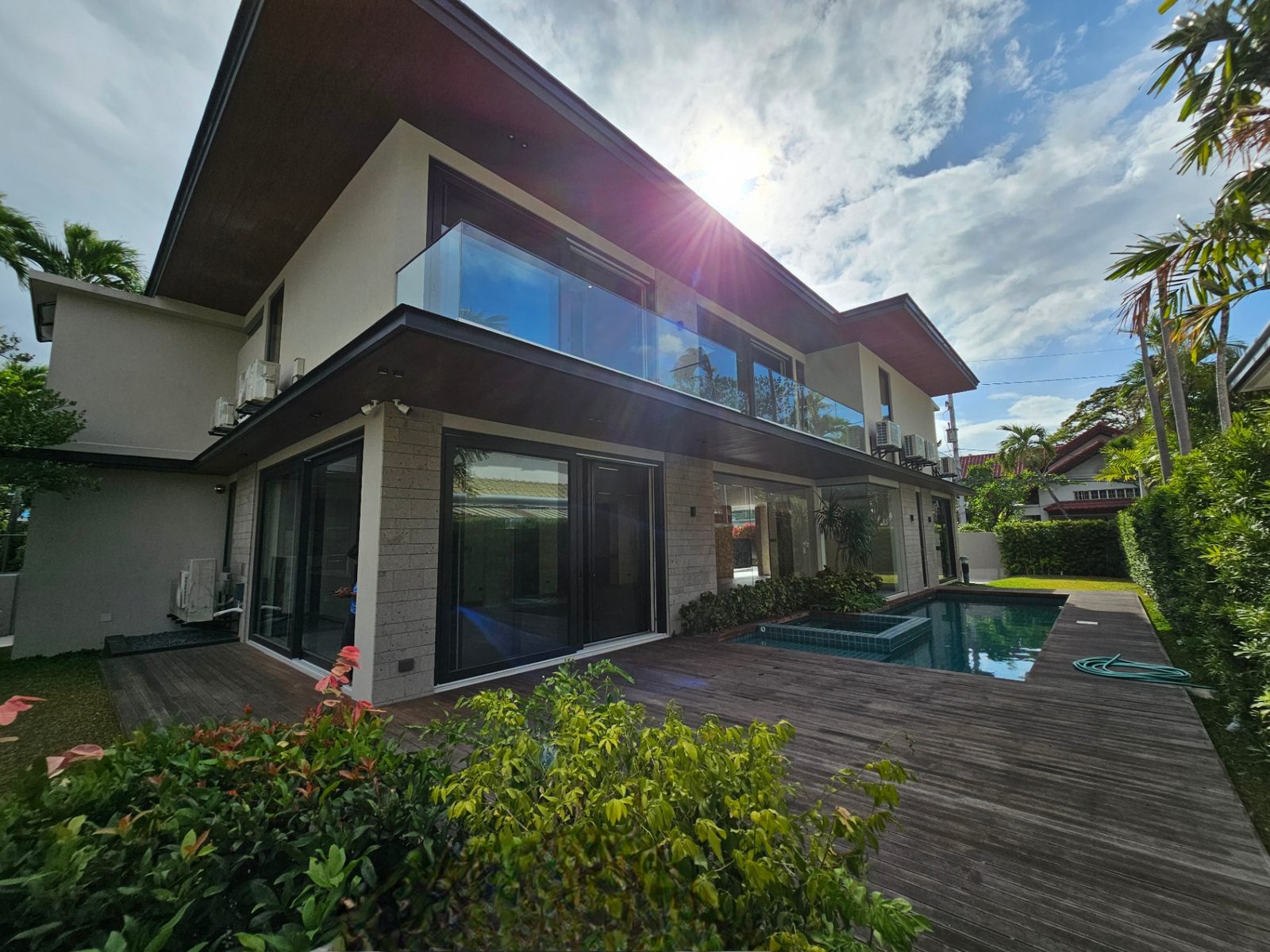 Rear elevation with resort swimming pool, timber deck and floor-to-ceiling glass