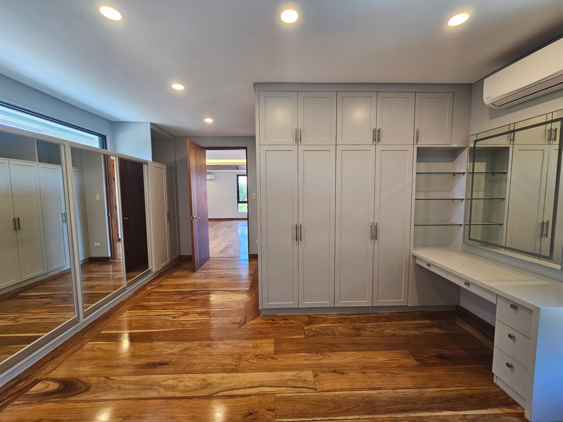 Walk-in closet with mirrored wardrobes and vanity station
