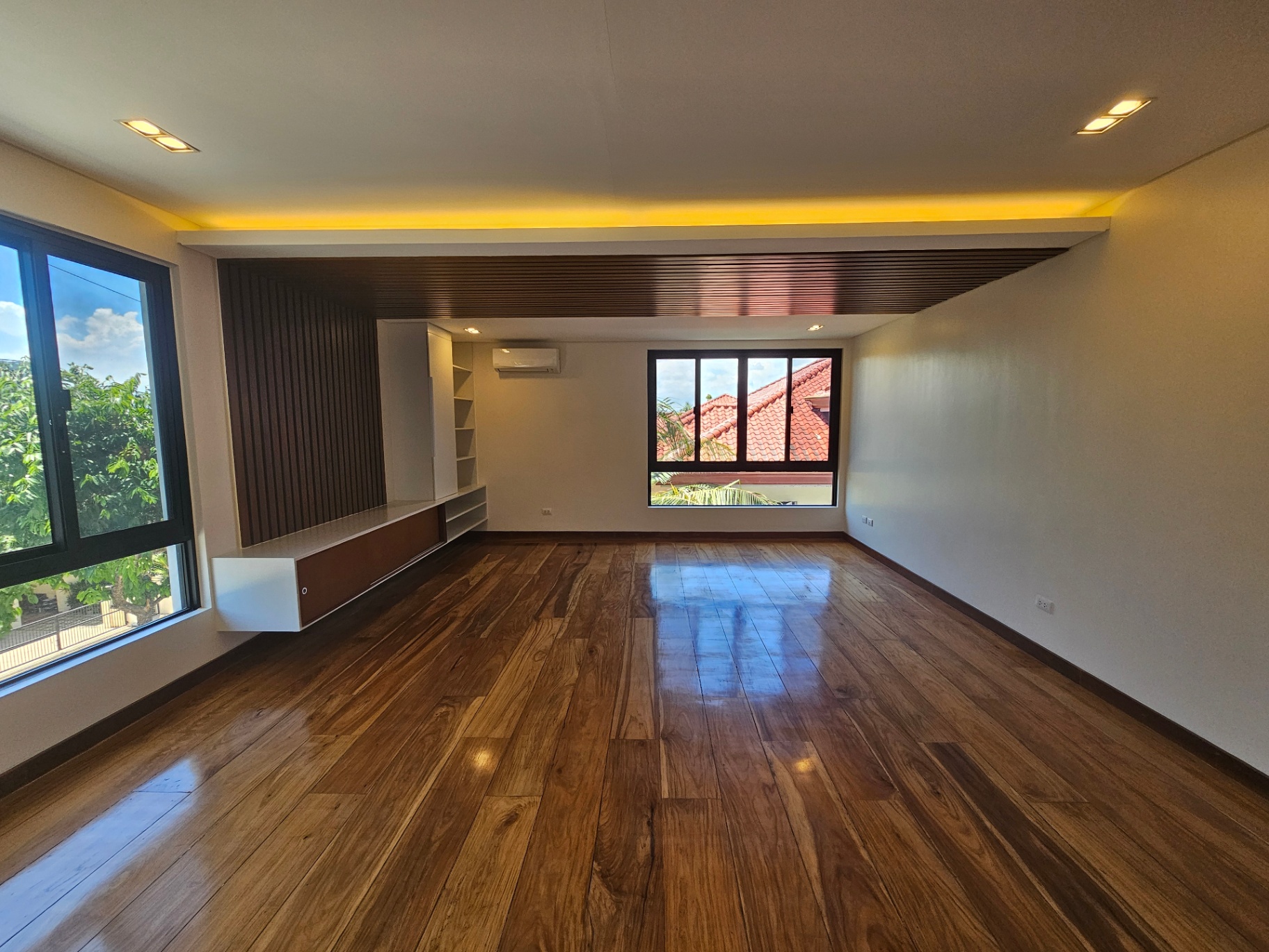 Family room with solid Narra wood flooring and garden views