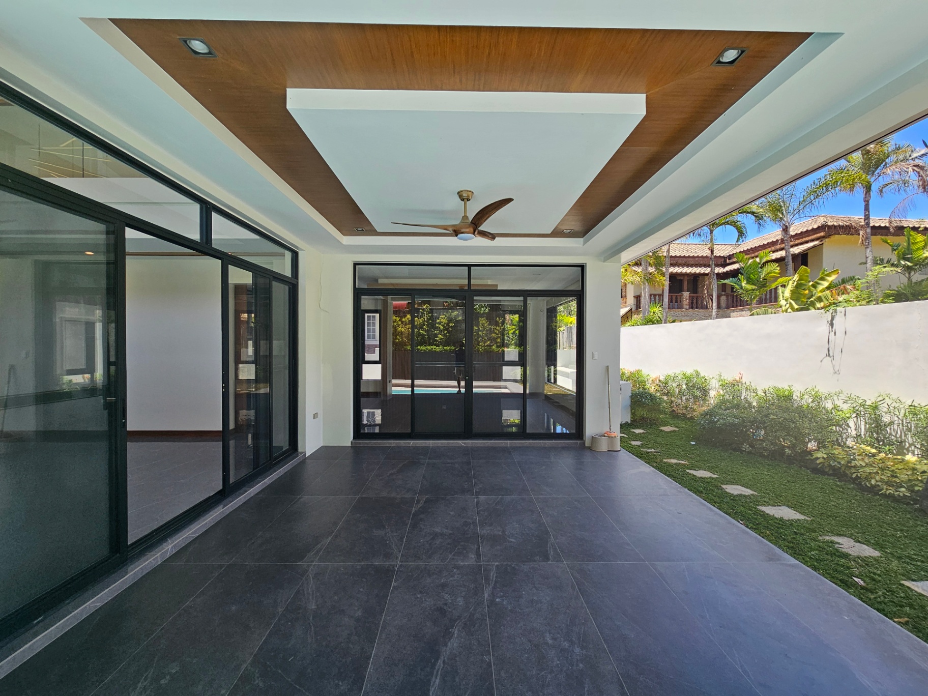 Covered lanai with timber ceiling opening to the garden