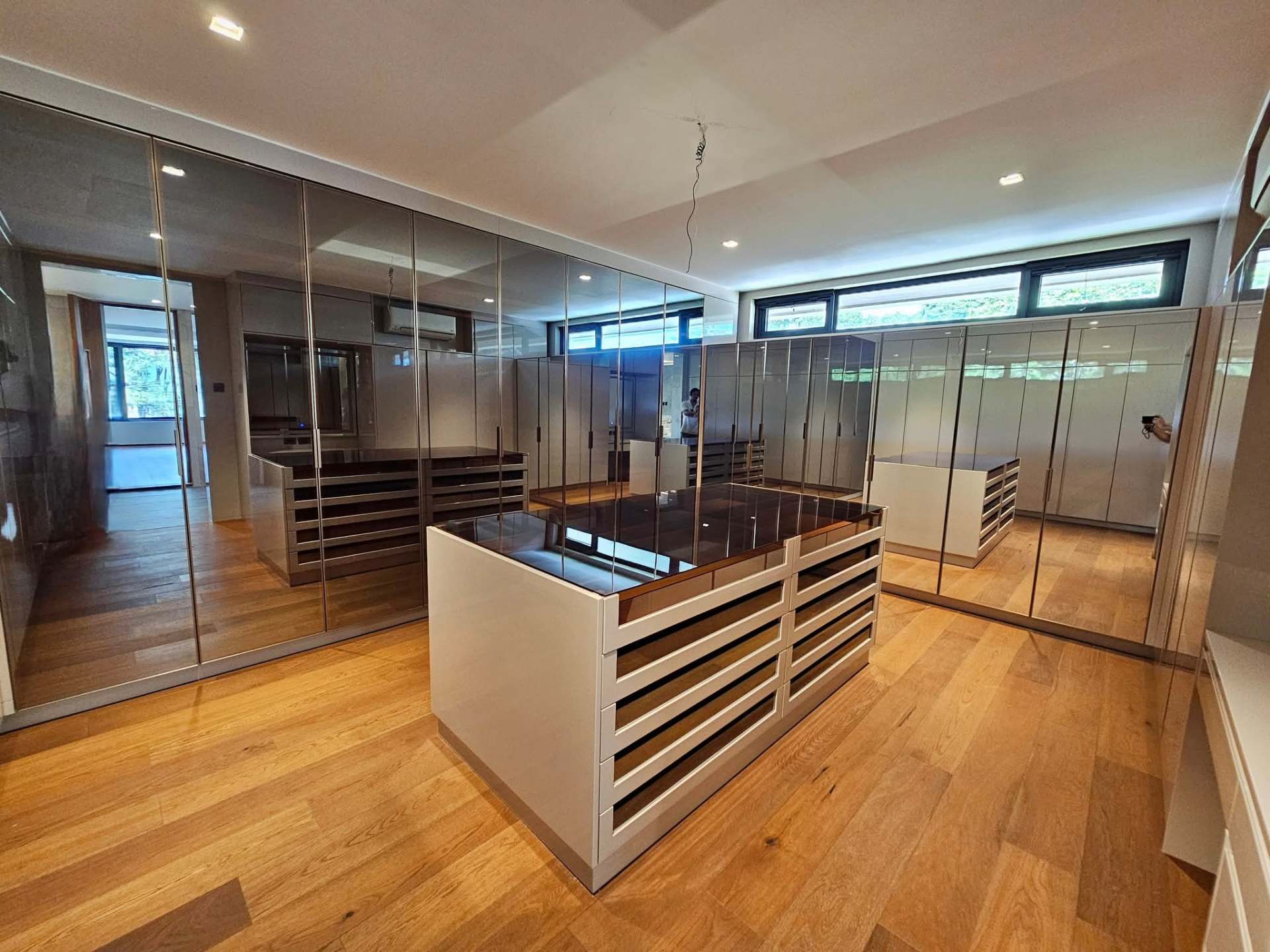 Master walk-in closet with mirrored cabinetry and central island