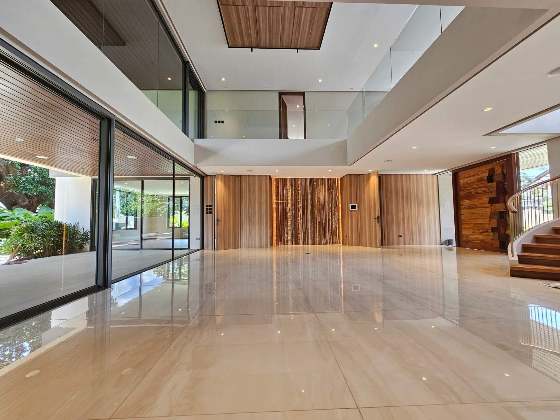 Double-height grand foyer with onyx feature wall and Narra cladding