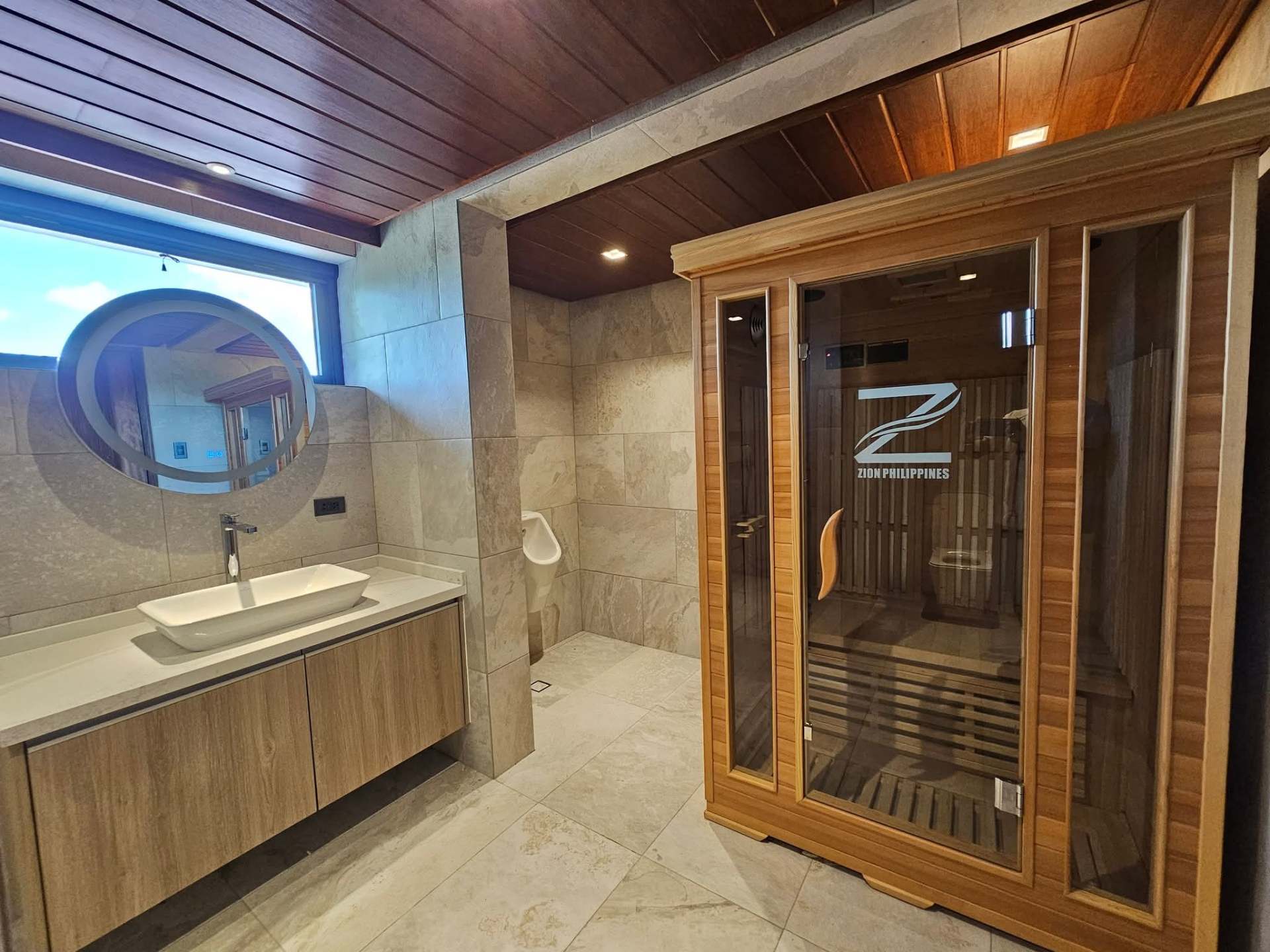 Wellness suite with sauna cabin and stone-tiled vanity