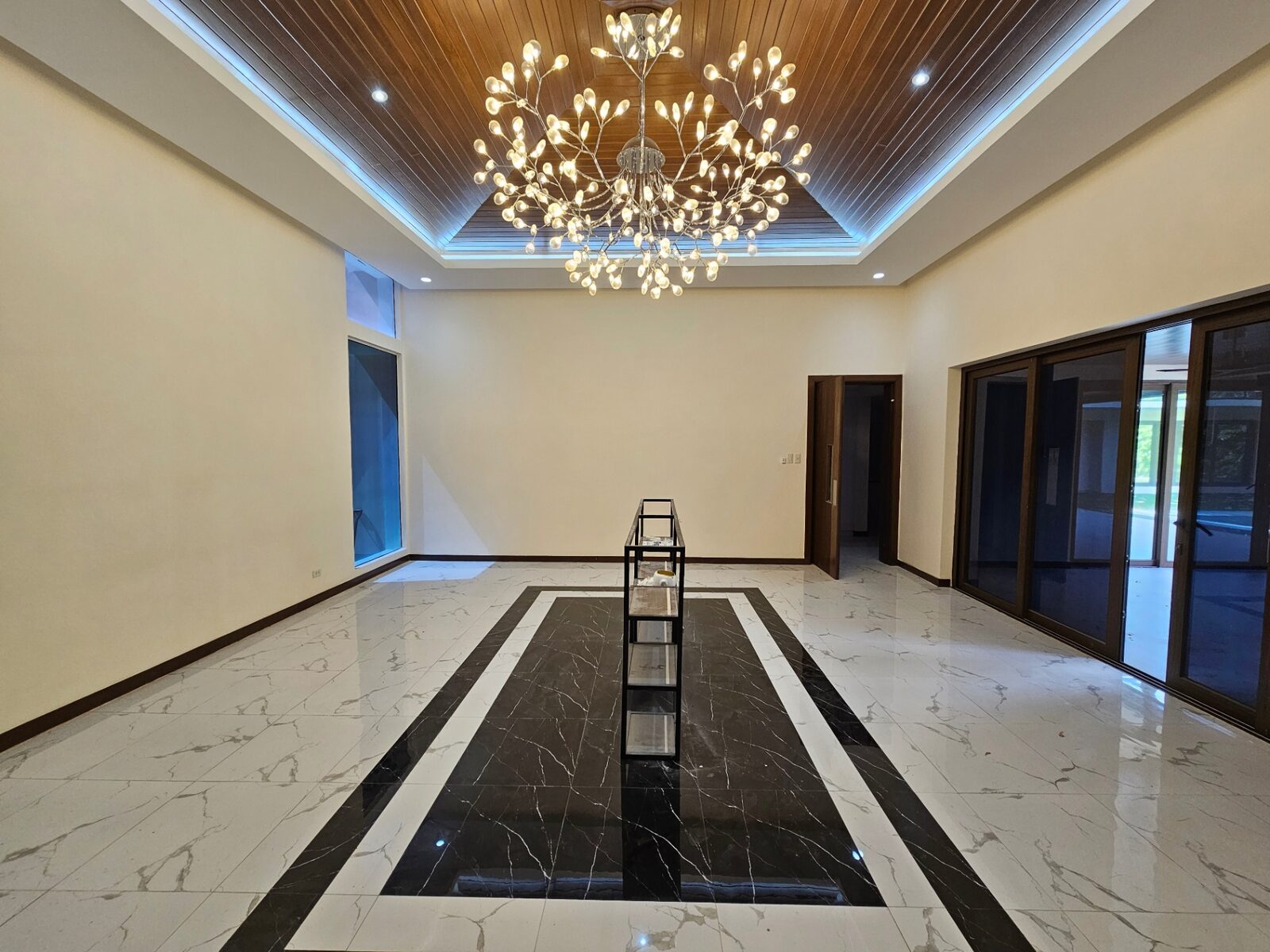 Living and dining hall with statement chandelier and marble inlay floor