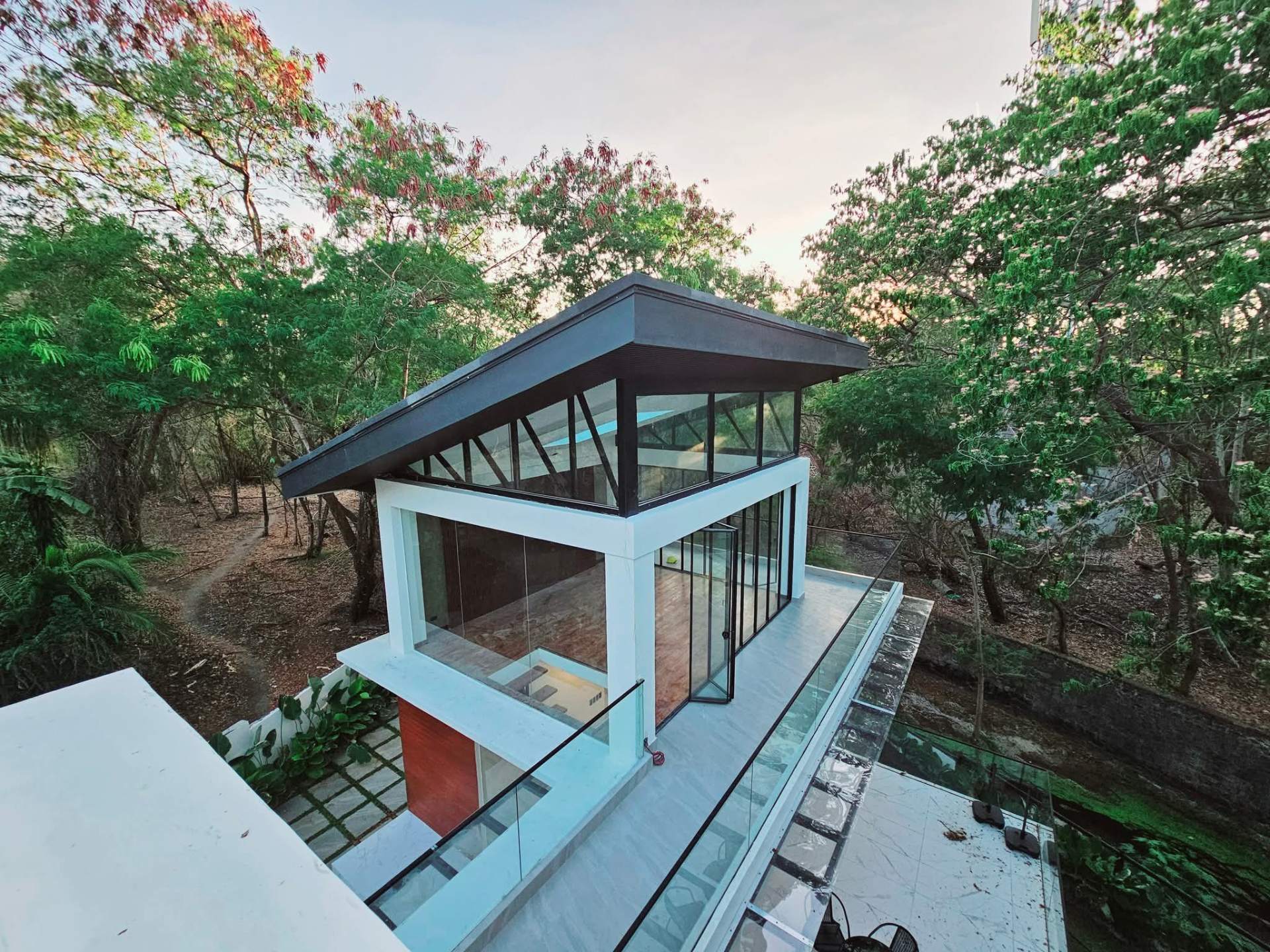 Two-storey glass cabana suspended over the ravine