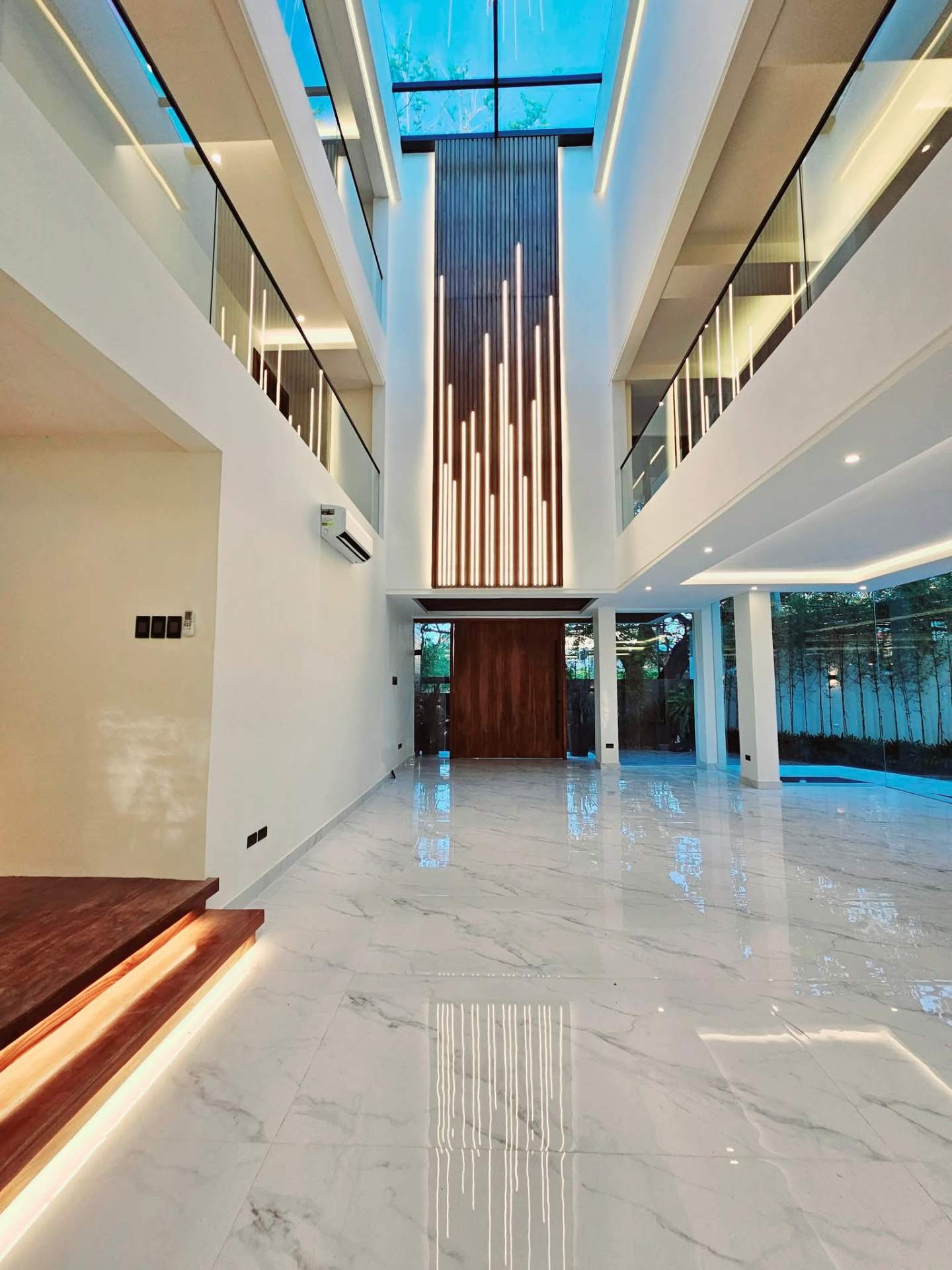 Double-height foyer with skylight and timber slat feature wall