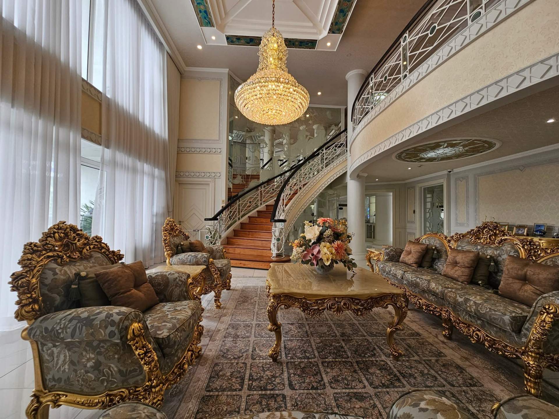 Grand foyer with crystal chandelier and gilded baroque seating