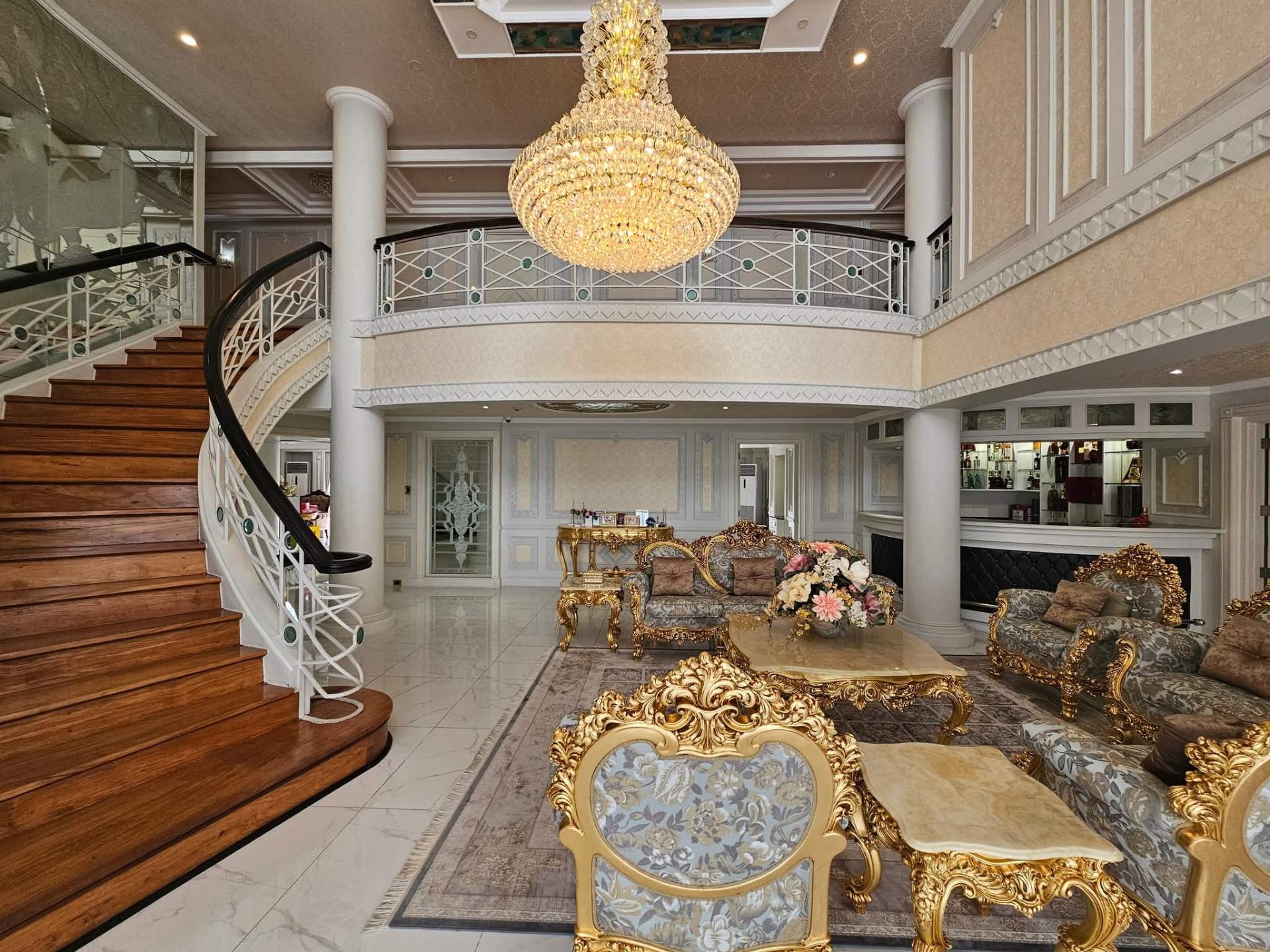 Double-height great room with sweeping staircase and chandelier