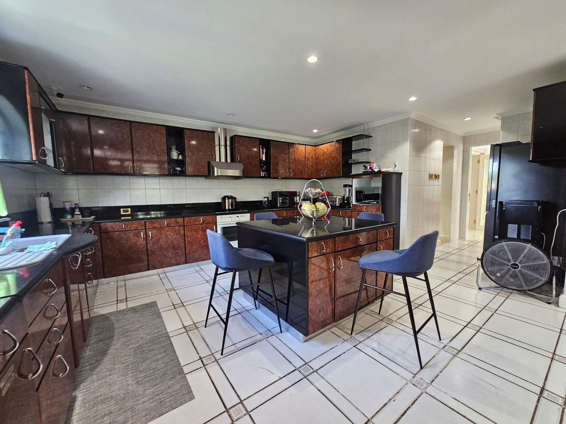 Spacious kitchen with island, burlwood cabinetry, and stone counters