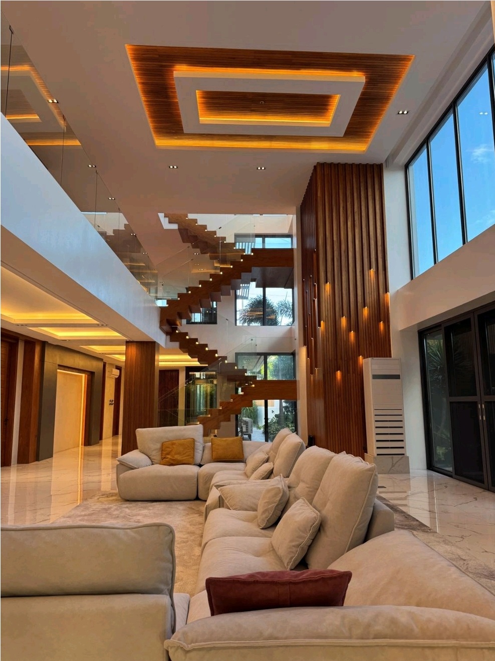 Double-height grand living area with floating staircase and Narra column