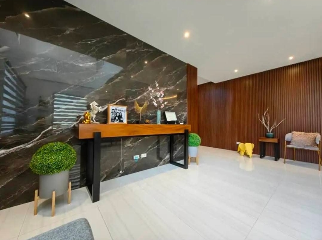 Grand foyer with marble feature wall and warm wood paneling