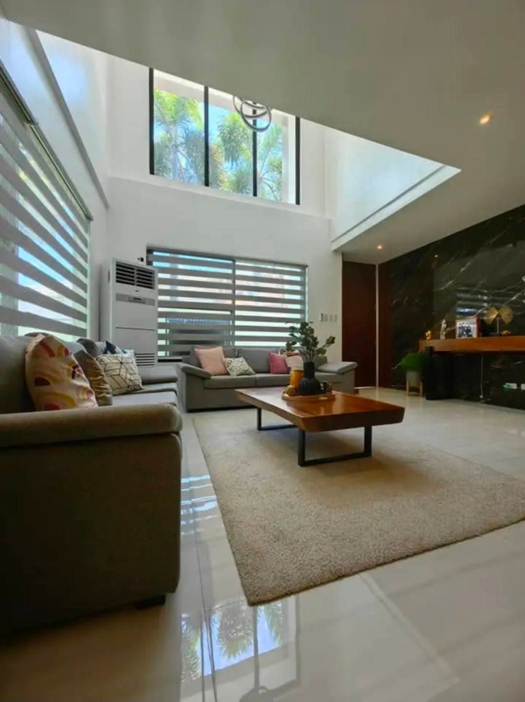 Double-height living room with marble accent wall