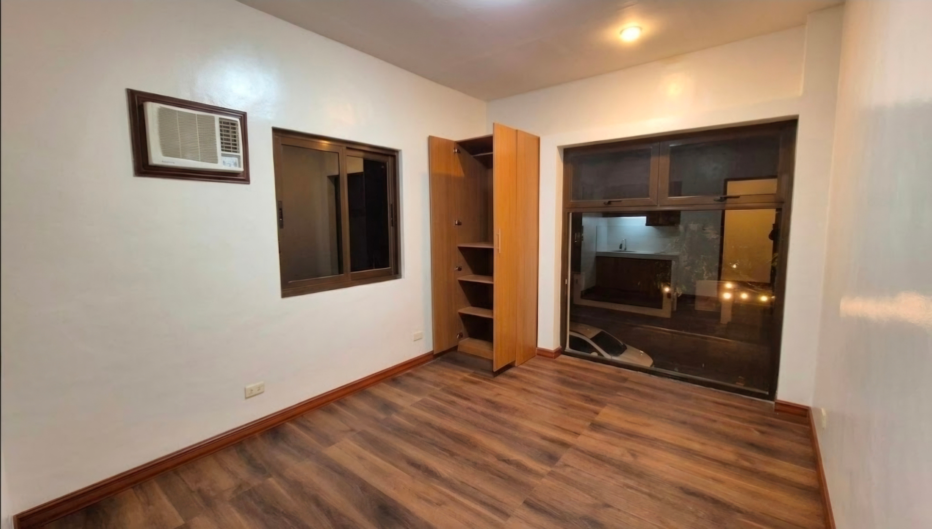 Bright bedroom with built-in storage and wood floors
