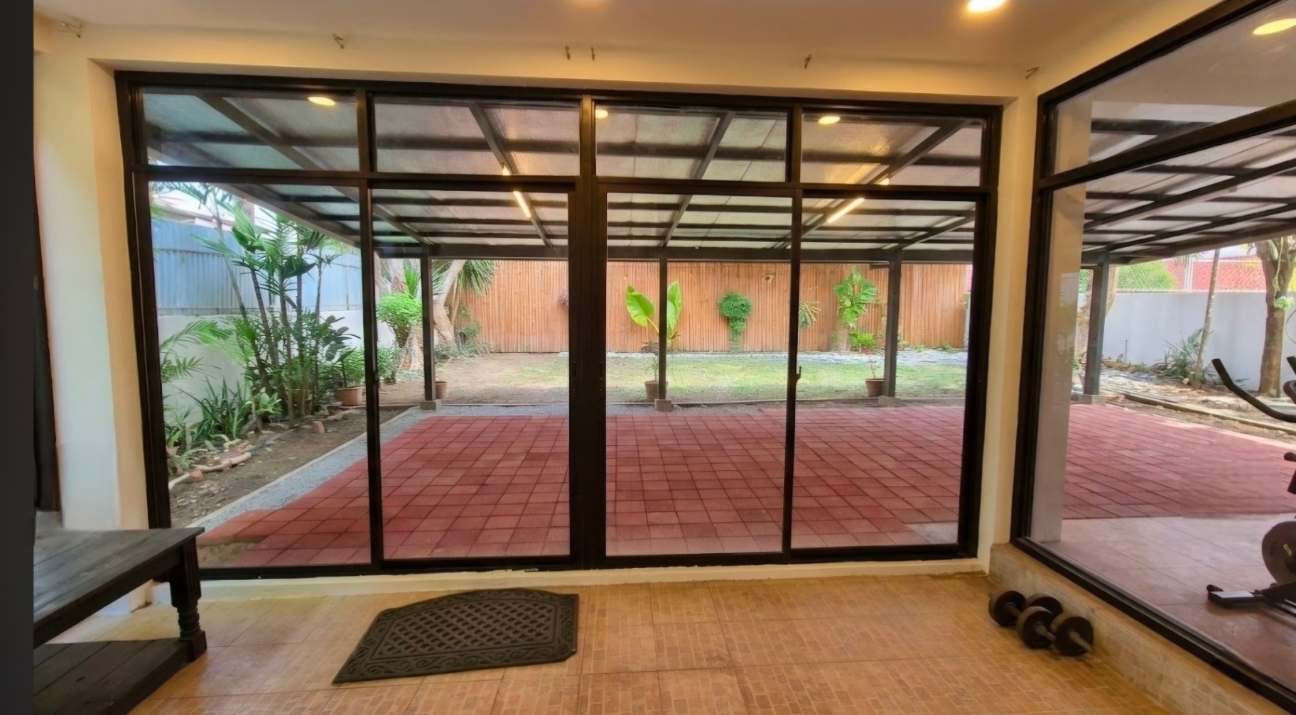 Floor-to-ceiling glass lanai opening to the garden