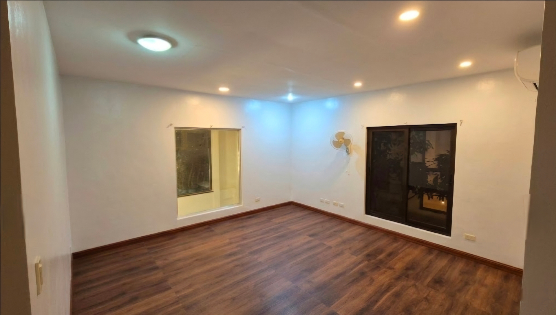 Spacious living area with warm wood flooring