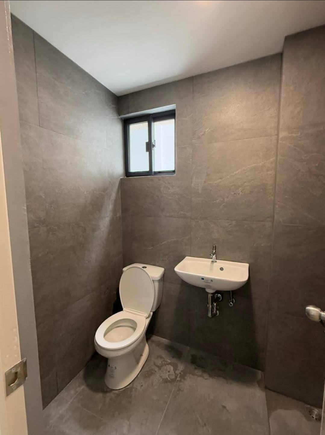 Stone-clad bathroom with wall-hung fixtures