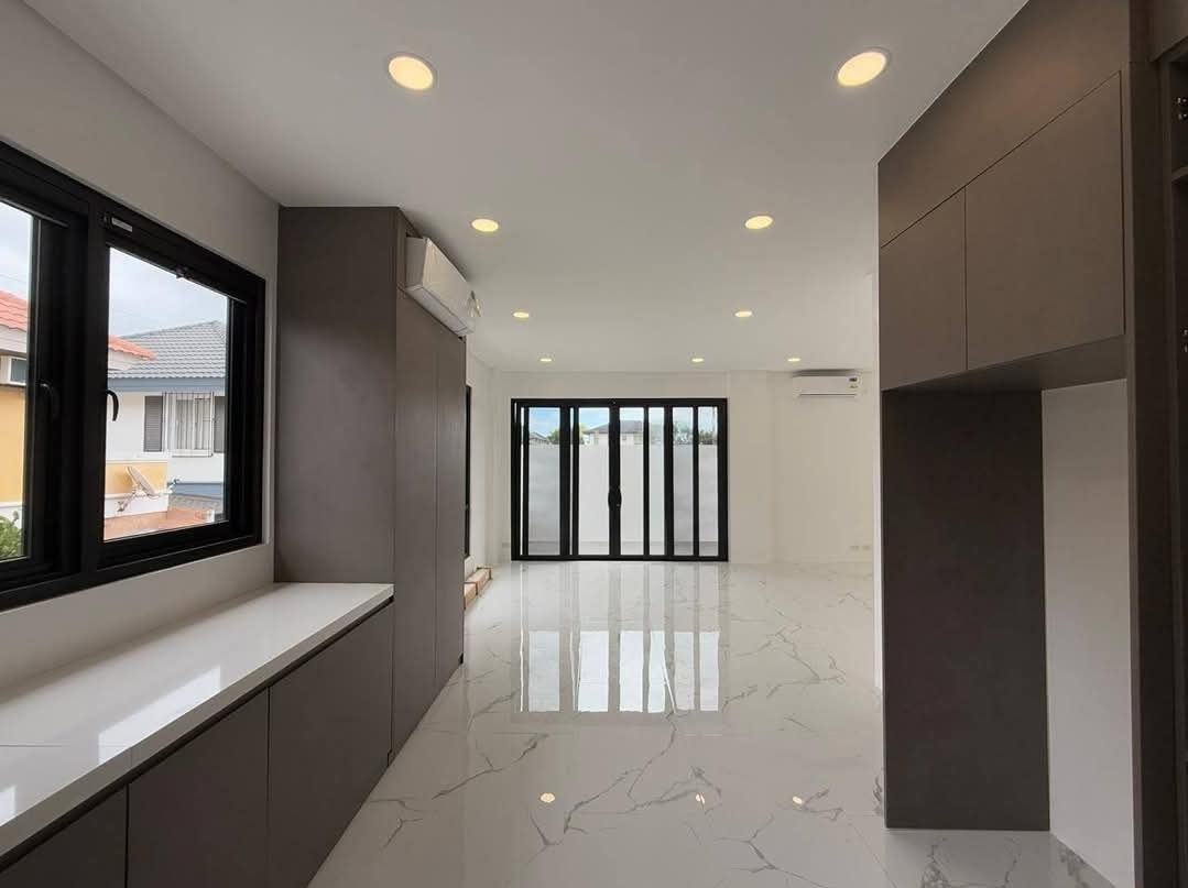 Open living space with bi-fold glass doors and marble flooring