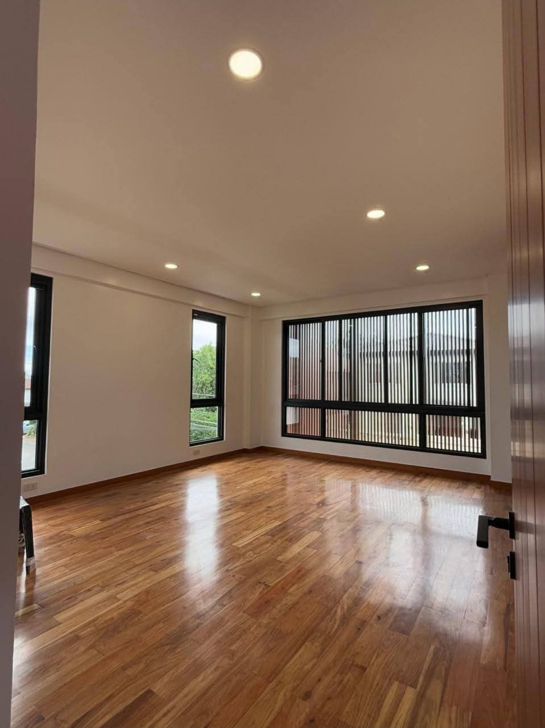 Master suite with solid Narra flooring and floor-to-ceiling fenestration
