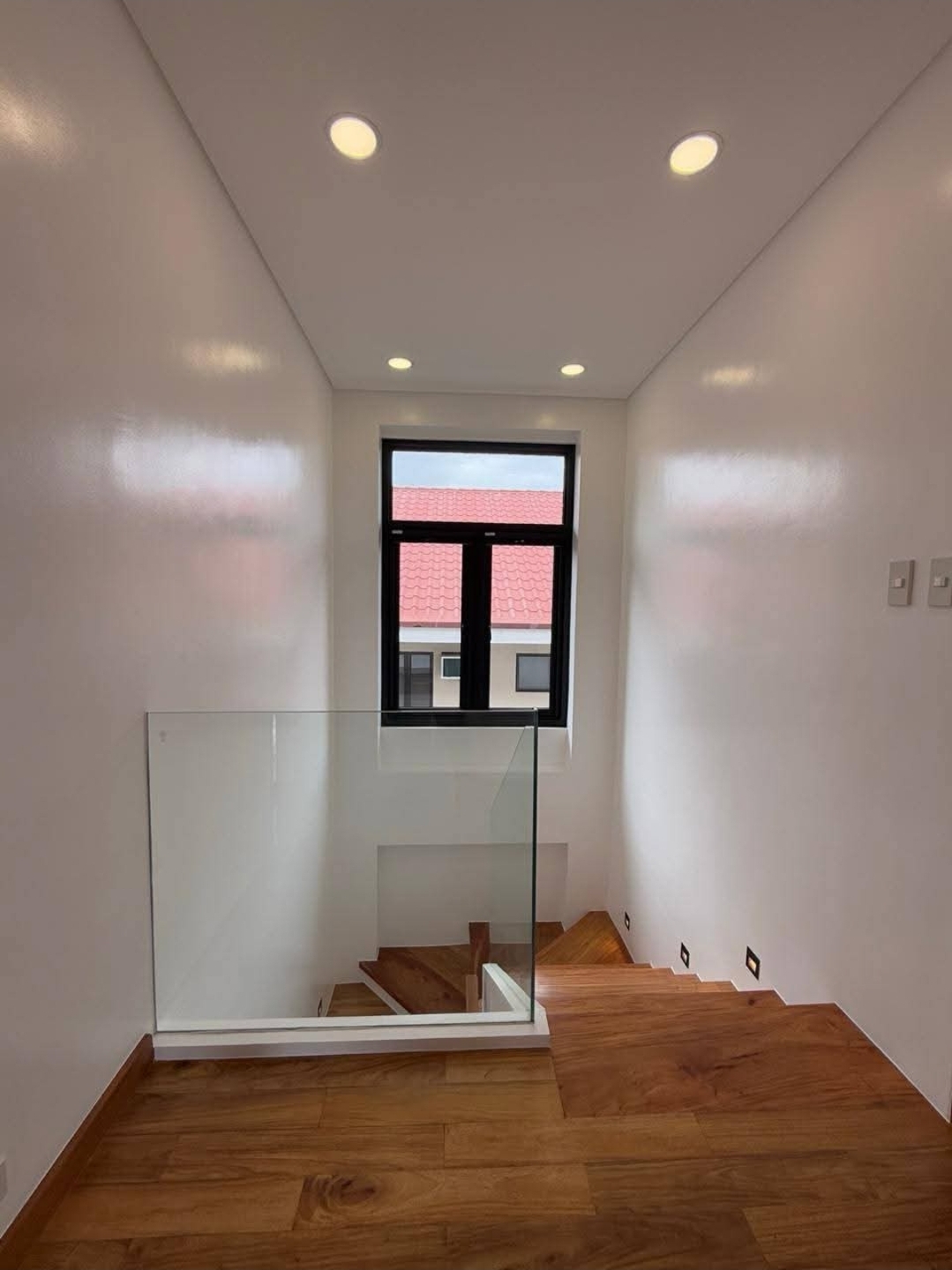 Stair landing with frameless glass balustrade and Narra treads