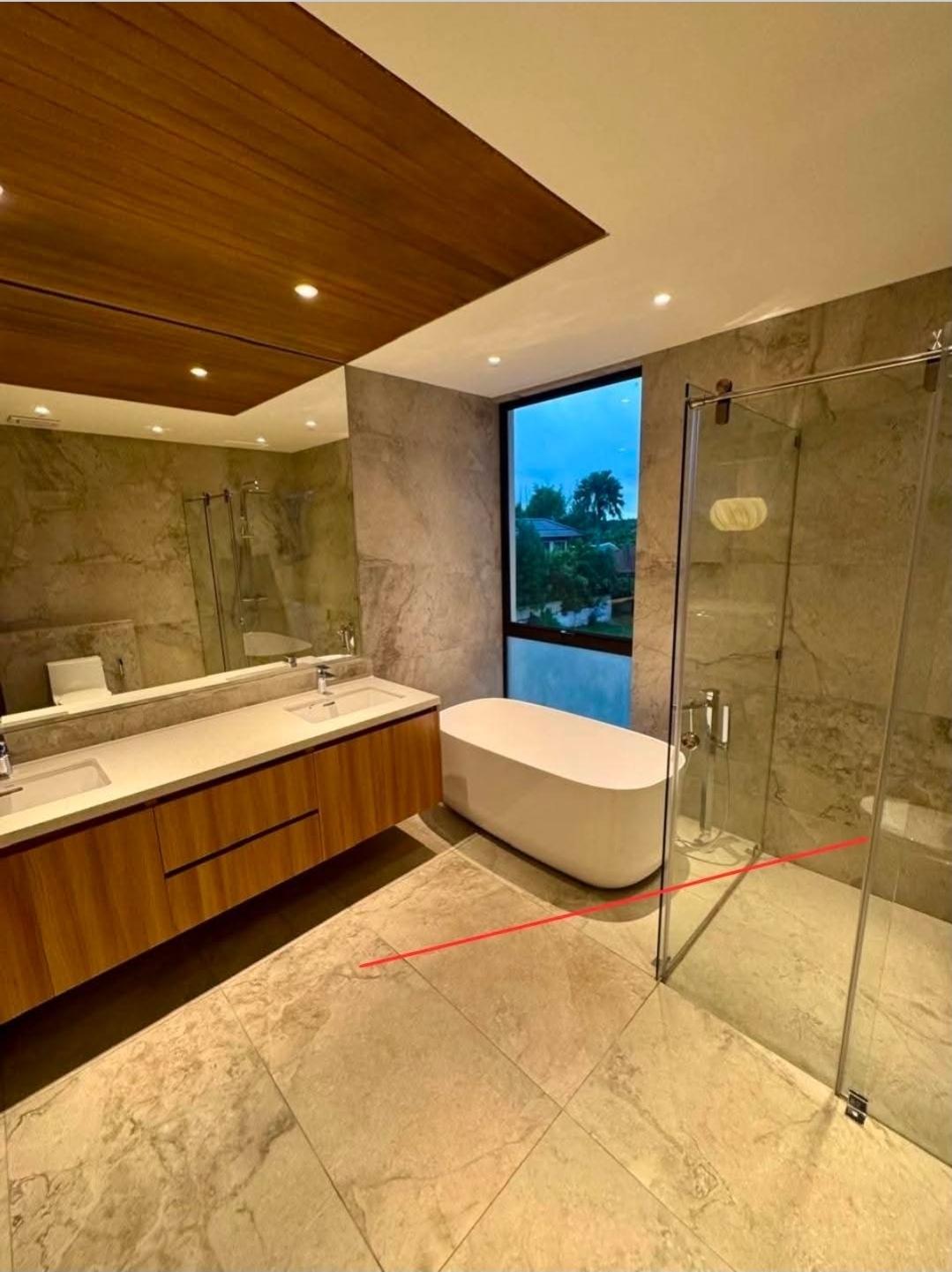 Master bath with marble cladding, freestanding soaking tub, and walk-in rain shower